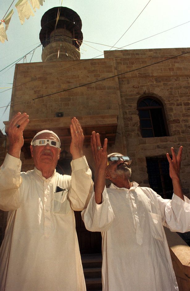 Muslim worshippers outside a mosque in Sidon, Lebanon, asking for mercy from Allah through prayer, during a solar eclipse